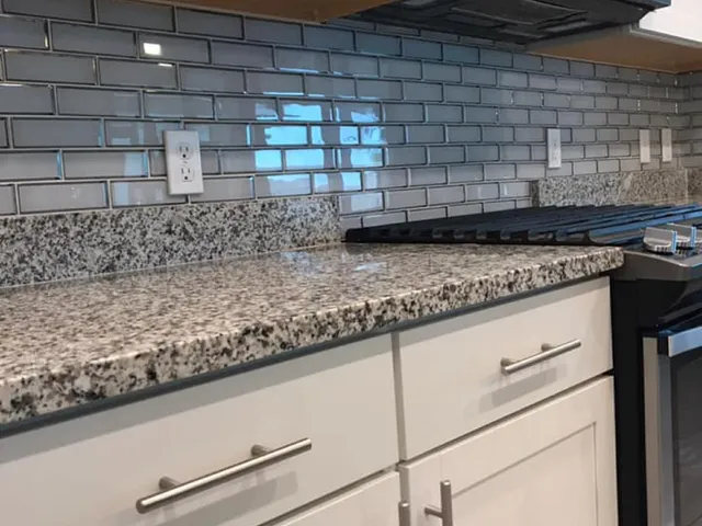 Completed kitchen backsplash above a granite countertop