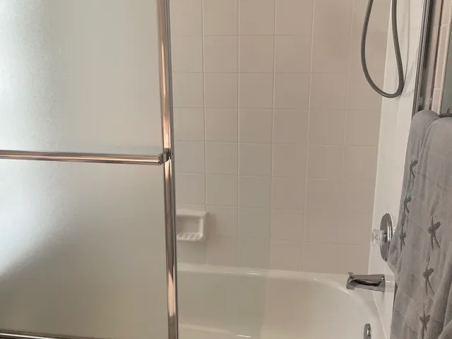 Tub surround with white subway tile and a built-in niche