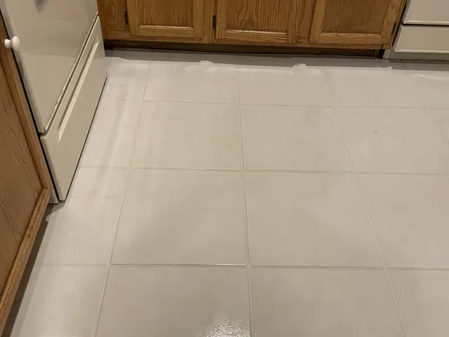 The same kitchen tile floor with clean, light grout lines after professional cleaning