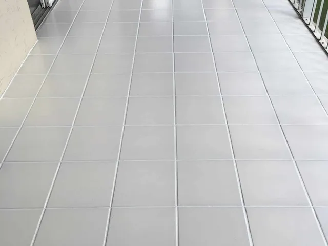 The same beige tile floor with uniform light grout after color sealing