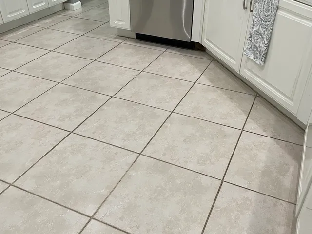 Kitchen tile floor with stained grout before treatment