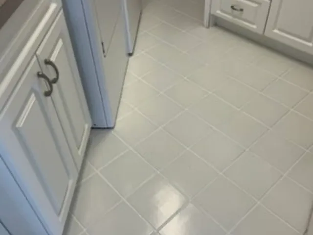 The same kitchen floor with clean, uniform light grout after cleaning and color sealing