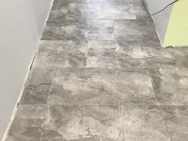 Finished gray porcelain plank floor near sliding doors to a lanai