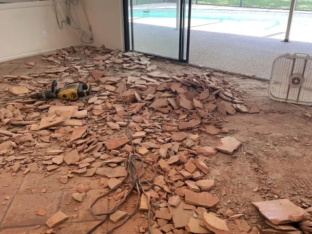 Great room during demolition with old floor tile broken up and piled before new installation