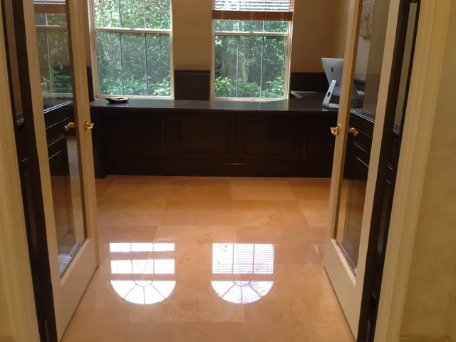 Polished marble floor reflecting light near sliding glass doors