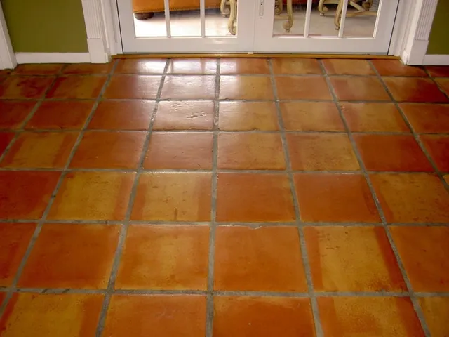 Dull, worn Saltillo tile kitchen floor with faded color before restoration