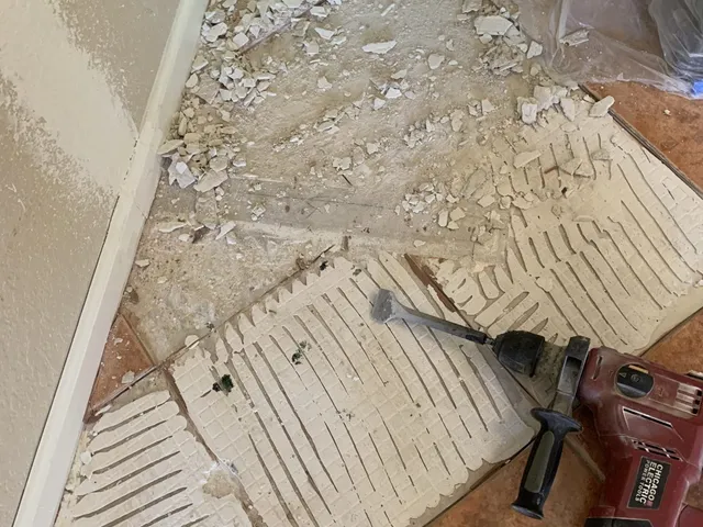 Cracked and broken floor tiles removed down to the slab before replacement