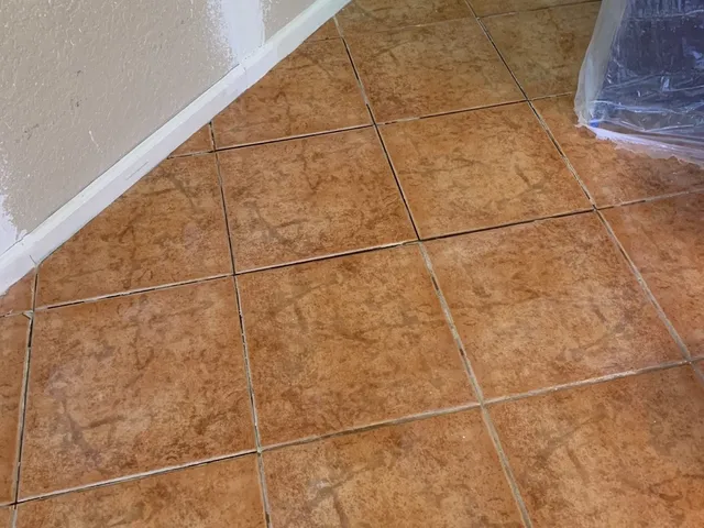 Replacement tiles set and grouted to match the surrounding floor