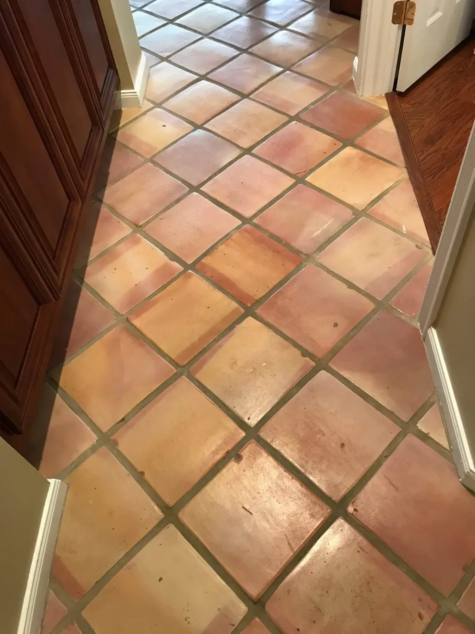Before: Mexican Saltillo tile hallway with dull tile and gray grout before, and glossy tile with bright grout after